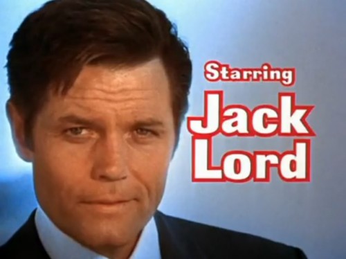 Jack Lord is Detective Lieutenant Steve McGarrett - the only man on the beach in suit, tie and fancy shoes. ('Hawaii Five-O,' 1973)
