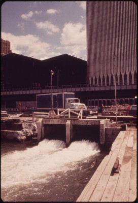 'Outflow of Drainage from the World Trade Center, New York's Latest Giant, Under Construction between Vesey and Liberty Streets in Lower Manhattan. There Is No Provision for Waste Treatment as Is the Case with All Westside Buildings, Sewage Will Go Directly Into the Already Badly Polluted Hudson River - Wil Blanche.'